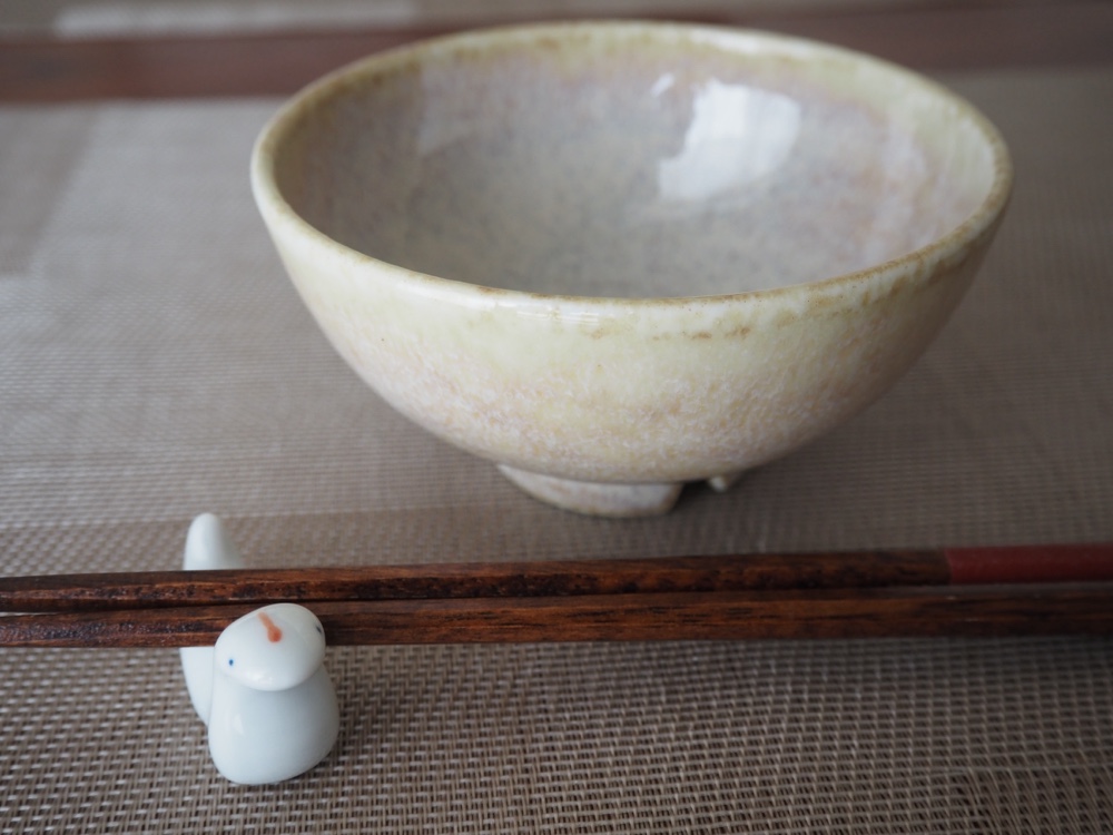 ランチョンマットの上に空のお茶碗と蛇の箸置きとお箸が一膳置いている