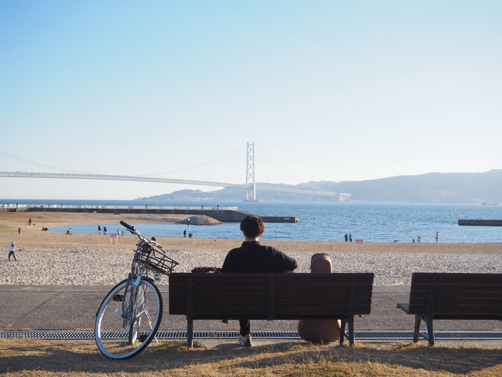 大蔵海岸で弾き語りをする男性の後ろ姿